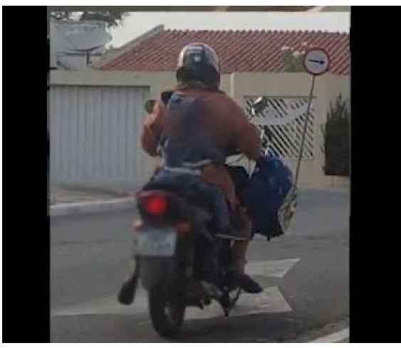 Mãe amarra criança ao corpo para andar de moto